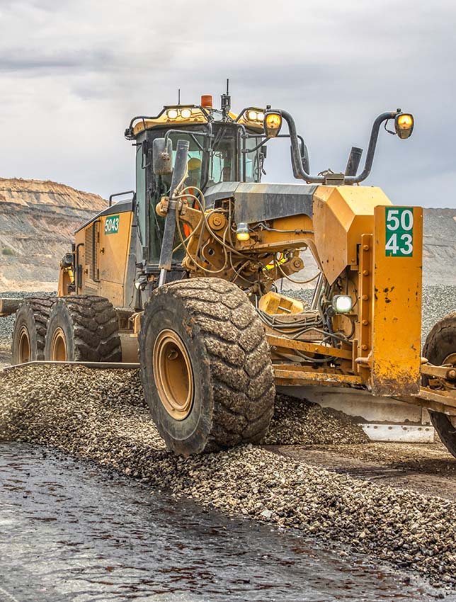 A grader and a truck repairing the road and putting water on a road in a diamond mine in Jwaneng, Botswana