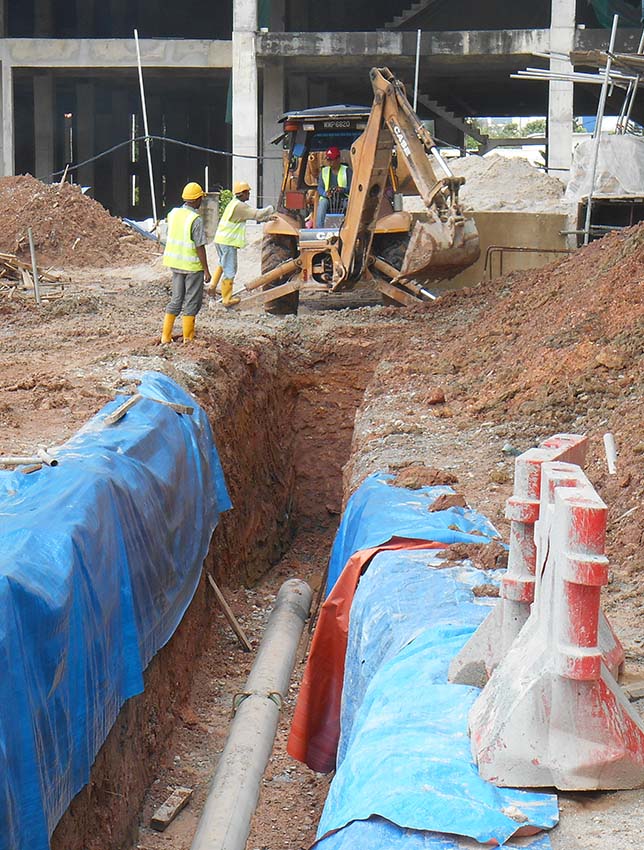 Underground utility and services pipe lay by workers at the cons