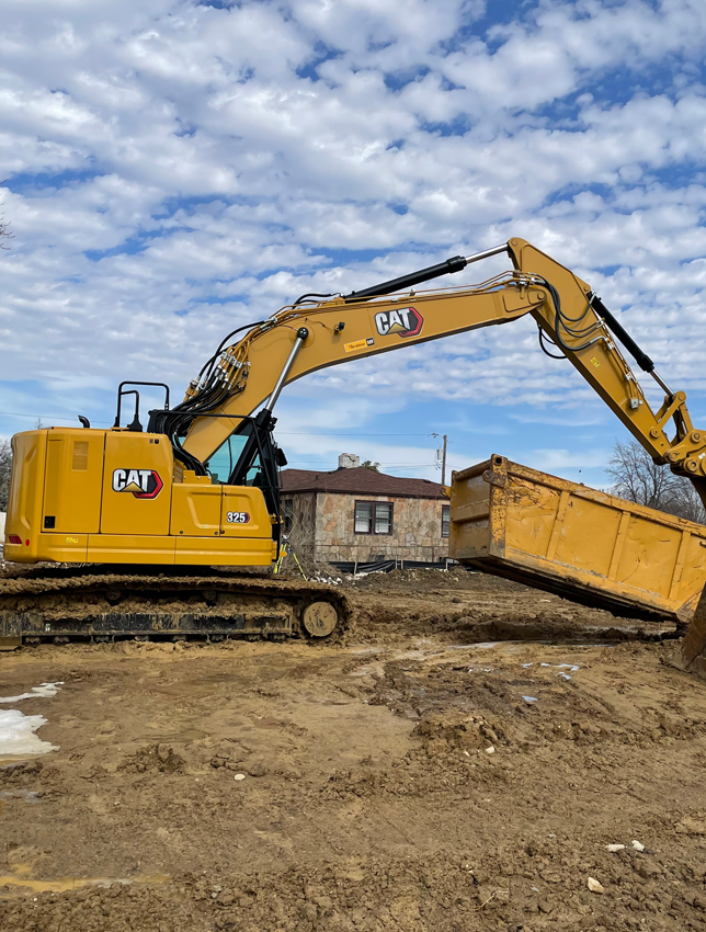 Yellow Excavator digging up dirt